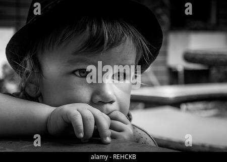 Un portrait en noir et blanc d'un adorable petit garçon de 2 ans portant un chapeau. Banque D'Images