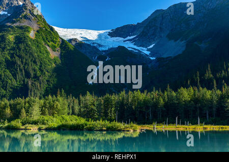 Une piscine turquoise reflète l'été de verdure au pied du glacier de l'Explorateur à Portage Valley, Alaska Banque D'Images