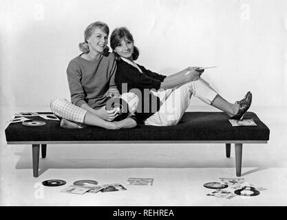 1960 Style de vie. Deux jeunes filles dans les années 60, les vêtements sont assis ensemble holding music records. Suède 1960 Banque D'Images