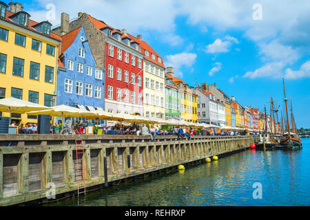 Les touristes sur Nyhavn embankment avec cafés et restaurants de journée ensoleillée, des bateaux naviguant par canal, Copenhague, Danemark Banque D'Images