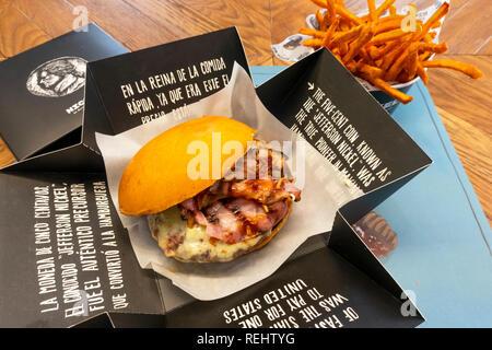 Un fromage et bacon burger avec frites de patates douces vient dans une boîte au Nickle Burger à Séville, Espagne Banque D'Images