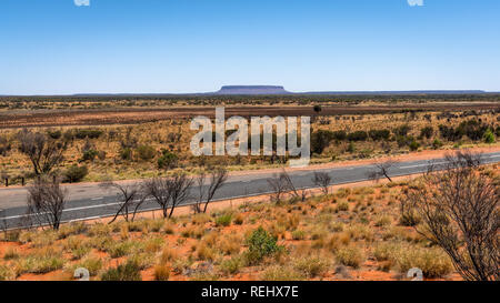 Vue éloignée sur le Mont Conner avec Lasseter Highway dans NT outback Australie centrale Banque D'Images