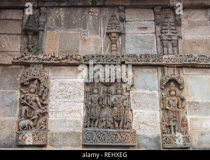 Belur, Karnataka, Inde - Novembre 2, 2013 : Temple Chennakeshava. Grand mur brun panneau latéral en pierre sculpture du seigneur Vishnu surrouned par ses femmes. Banque D'Images