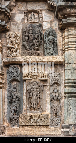 Belur, Karnataka, Inde - Novembre 2, 2013 : Temple Chennakeshava. Grand mur brun panneau latéral en pierre sculpture des trois principaux dieux chaque surrouned par Banque D'Images