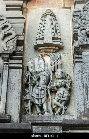 Belur, Karnataka, Inde - Novembre 2, 2013 : Temple Chennakeshava. Panneau de mur gris stone sculpture du seigneur Vishnu surrouned par ses deux conjoints Devi La Banque D'Images