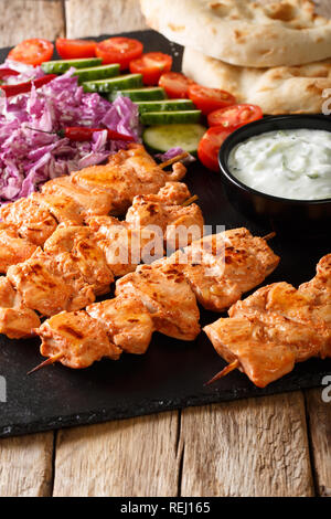 Taouk traditionnelle brochette de poulet avec une salade fraîche, sauce yogourt et de pain pita close-up sur la table verticale. Banque D'Images