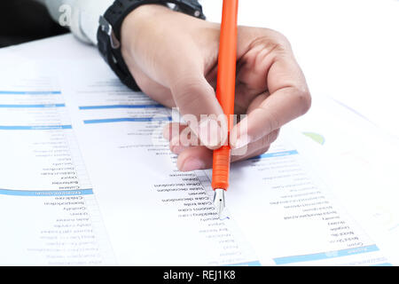 L'homme est à vérifier le travail sur le papier avec un stylo. Banque D'Images