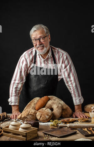 Homme âgé démontrant assortiment de boulangerie. Pâtisseries maison, de style rural Banque D'Images