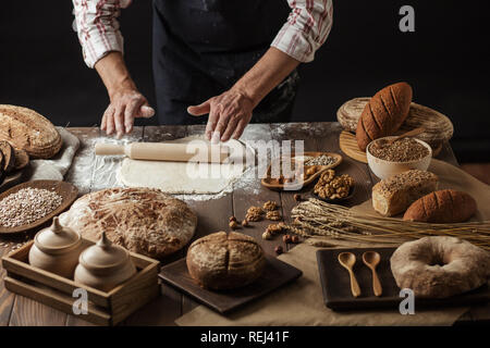 L'homme le déploiement de pâte sur une table de cuisine, Close up Banque D'Images