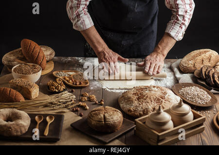 L'homme le déploiement de pâte sur une table de cuisine, Close up Banque D'Images