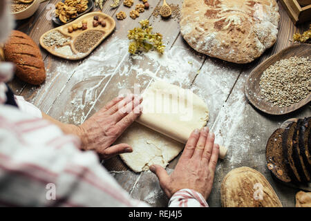 L'homme le déploiement de pâte sur une table de cuisine, Close up Banque D'Images