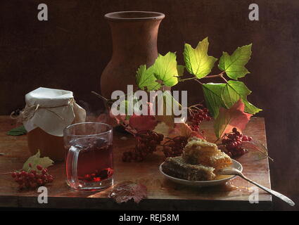 Nature morte avec du thé avec du miel et de la viorne Banque D'Images