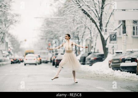 Belle jupe transparente en ballerine danse sur la rue des harfangs ville parmi les voitures. Banque D'Images