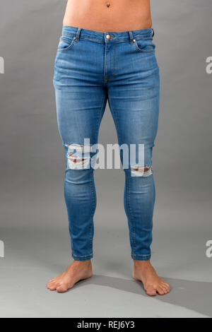 Homme moderne bleu sans marque skinny jeans déchirés isloated sur fond gris Banque D'Images