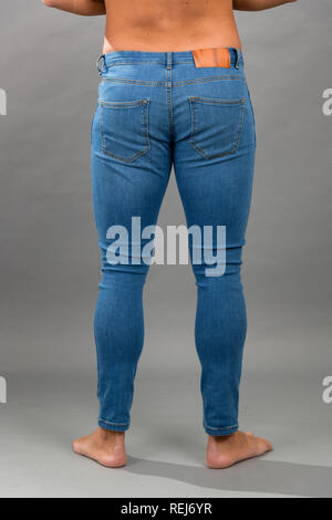 Homme moderne bleu sans marque skinny jeans déchirés isloated sur fond gris Banque D'Images