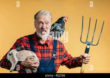 Frustrés en colère garderner tenant une fourche Banque D'Images