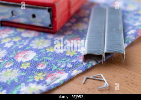 Agrafeuse et agrafes à upholster meubles. Accessoires pour les employés dans l'atelier de menuiserie. Fond clair Banque D'Images