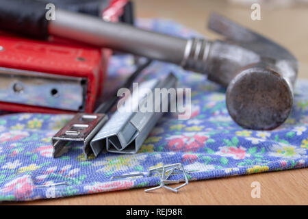 Agrafeuse et agrafes à upholster meubles. Accessoires pour les employés dans l'atelier de menuiserie. Fond clair Banque D'Images