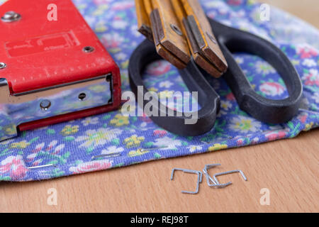 Agrafeuse et agrafes à upholster meubles. Accessoires pour les employés dans l'atelier de menuiserie. Fond clair Banque D'Images