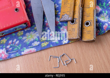 Agrafeuse et agrafes à upholster meubles. Accessoires pour les employés dans l'atelier de menuiserie. Fond clair Banque D'Images