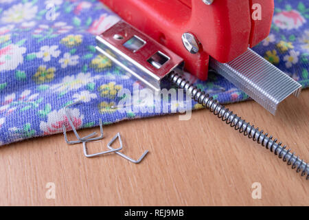 Agrafeuse et agrafes à upholster meubles. Accessoires pour les employés dans l'atelier de menuiserie. Fond clair Banque D'Images