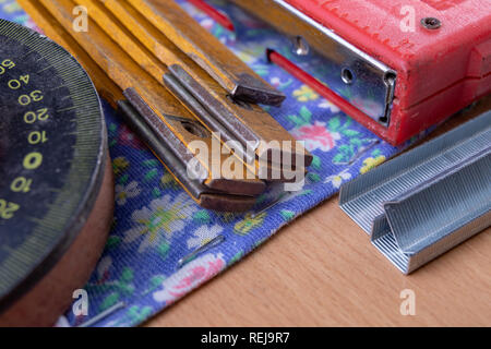 Agrafeuse et agrafes à upholster meubles. Accessoires pour les employés dans l'atelier de menuiserie. Fond clair Banque D'Images