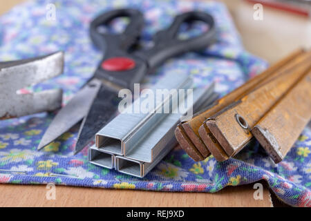 Agrafeuse et agrafes à upholster meubles. Accessoires pour les employés dans l'atelier de menuiserie. Fond clair Banque D'Images