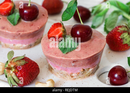 Les gâteaux de fraise et de cerise avec les baies fraîches, menthe, noix. La nourriture végétalienne saine notion Banque D'Images