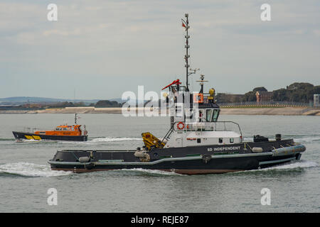 Les services maritimes de Serco indépendant SD remorqueur passant un bateau-pilote, tandis que sur son chemin dans le port de Portsmouth, Royaume-Uni le 19 avril 2016. Banque D'Images