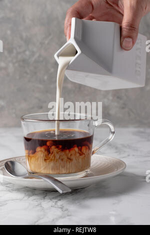 Verser la crème dans le café avec crème Swirls Banque D'Images