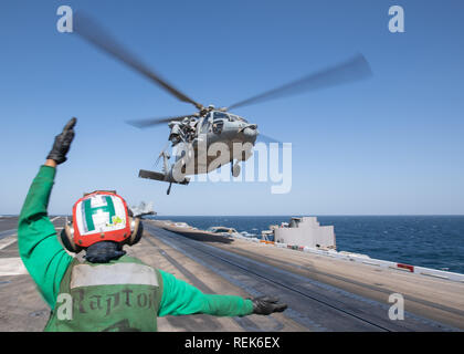 Un MH-60S Sea Hawk, affecté à l'Escadron d'hélicoptères de combat de la mer (HSC), 14 terrains sur le pont d'envol du porte-avions USS JOHN C. STENNIS (CVN 74) dans la mer d'Oman, le 21 janvier 2018. Le John C. Stennis dans le groupe est déployé pour la 5e flotte américaine zone d'opérations à l'appui des opérations navales pour assurer la stabilité et la sécurité maritime dans la région Centrale, reliant la Méditerranée et le Pacifique à travers l'ouest de l'Océan indien et trois points d'étranglement stratégiques. (U.S. Photo illustration marine Spécialiste de la communication de masse par Jarrod Marin A. Schad) Banque D'Images