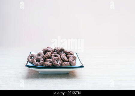 Grains entiers céréales croustillantes au chocolat toute l'avoine dans un plat carré en bois sur table. Snack-organique sain, nourriture, petit déjeuner Concept avec Copy-Spac Banque D'Images