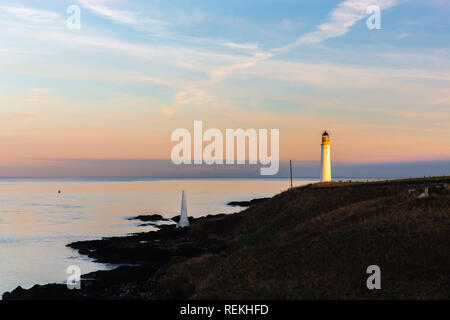 Scurdie Ness phare au crépuscule. Le phare protège l'expédition à partir de l'éperon rocheux de la côte écossaise. Banque D'Images