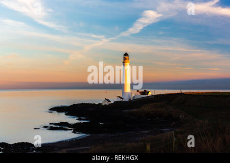 Scurdie Ness phare au crépuscule. Le phare protège l'expédition à partir de l'éperon rocheux de la côte écossaise. Banque D'Images