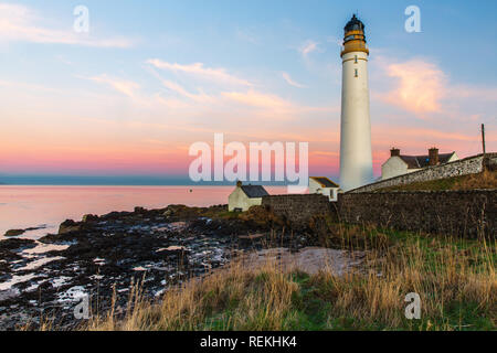 Scurdie Ness phare au crépuscule. Le phare protège l'expédition à partir de l'éperon rocheux de la côte écossaise. Banque D'Images