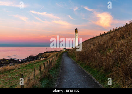 Scurdie Ness phare au crépuscule. Le phare protège l'expédition à partir de l'éperon rocheux de la côte écossaise. Banque D'Images