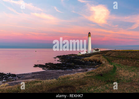 Scurdie Ness phare au crépuscule. Le phare protège l'expédition à partir de l'éperon rocheux de la côte écossaise. Banque D'Images