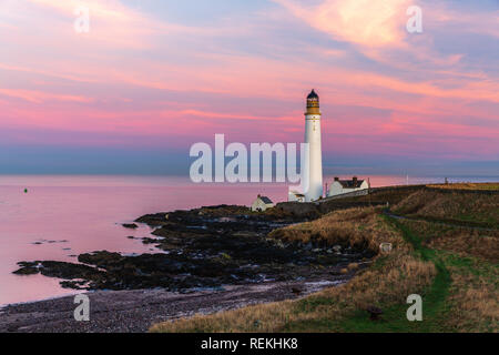 Scurdie Ness phare au crépuscule. Le phare protège l'expédition à partir de l'éperon rocheux de la côte écossaise. Banque D'Images