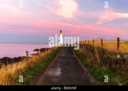 Scurdie Ness phare au crépuscule. Le phare protège l'expédition à partir de l'éperon rocheux de la côte écossaise. Banque D'Images