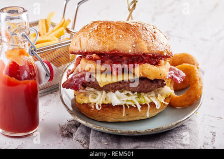 Surf and Turf burger avec anneaux de calmars, bacon croustillant et un patty viande garnie de fromage fondu et de ketchup Banque D'Images