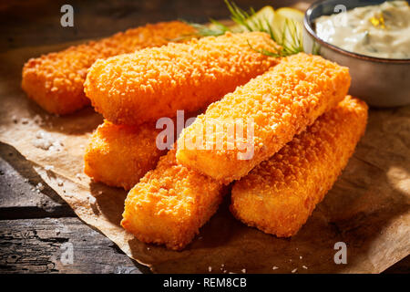 Vue rapprochée de bâtonnets de poisson frit croustillant de chapelure servi avec sauce Banque D'Images