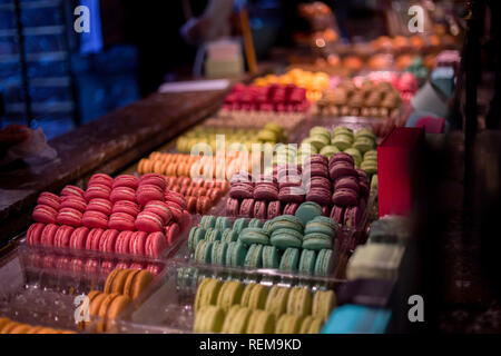 Un stand avec différentes saveurs de macarons à l'intérieur d'une boutique à Paris. Banque D'Images