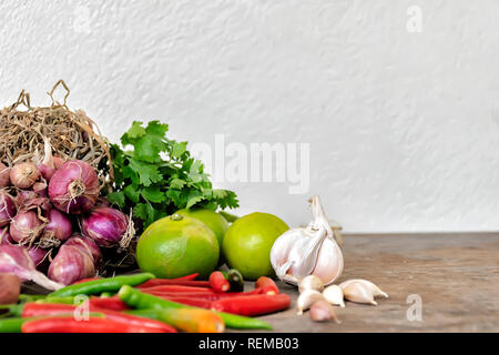 Concept d'assaisonnement. Composition de diverses herbes et épices isolé placé sur une table en bois. Échalotes, Ail, piment, coriandre, citron. Pour entrer dans l'espace t Banque D'Images