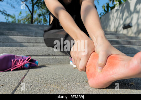 Jeune femme en massant son pied douloureux d'exercer et d'exploiter le sport et l'excercise concept. souffrant d'une blessure à la cheville alors que l'exercice et ru Banque D'Images