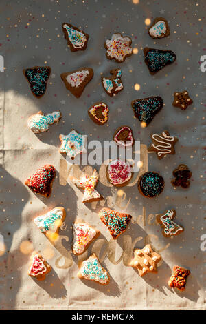 Christmas gingerbread cookies dans beaucoup de formes décorés de glaçage coloré, saupoudrer, cerise, chocolat, surmatelas, mettre sur du tissu en question Banque D'Images