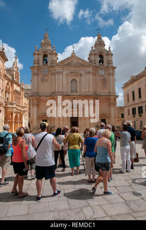 Un groupe de touristes d'admirer la façade de la Cathédrale St Paul à l'ancienne ville de Mdina à Malte. Banque D'Images