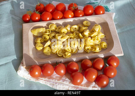 Tortellini farci de matières premières avec tomates Pachino Banque D'Images