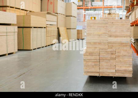 Dans l'entrepôt de bois. Avec les conseils de palettes dans le magasin de matériel. Paniers-boards dans le bâtiment Magasin. matériaux de construction. entrepôt avec variété de timb Banque D'Images