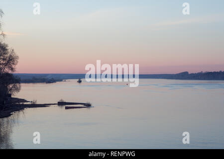 Printemps paysage paisible au coucher du soleil sur la rivière avec le navire et forêt en arrière-plan Banque D'Images