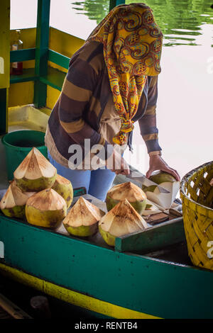 Couper une femme en bonne forme de noix de coco et servir pour une nouvelle boisson naturelle Banque D'Images